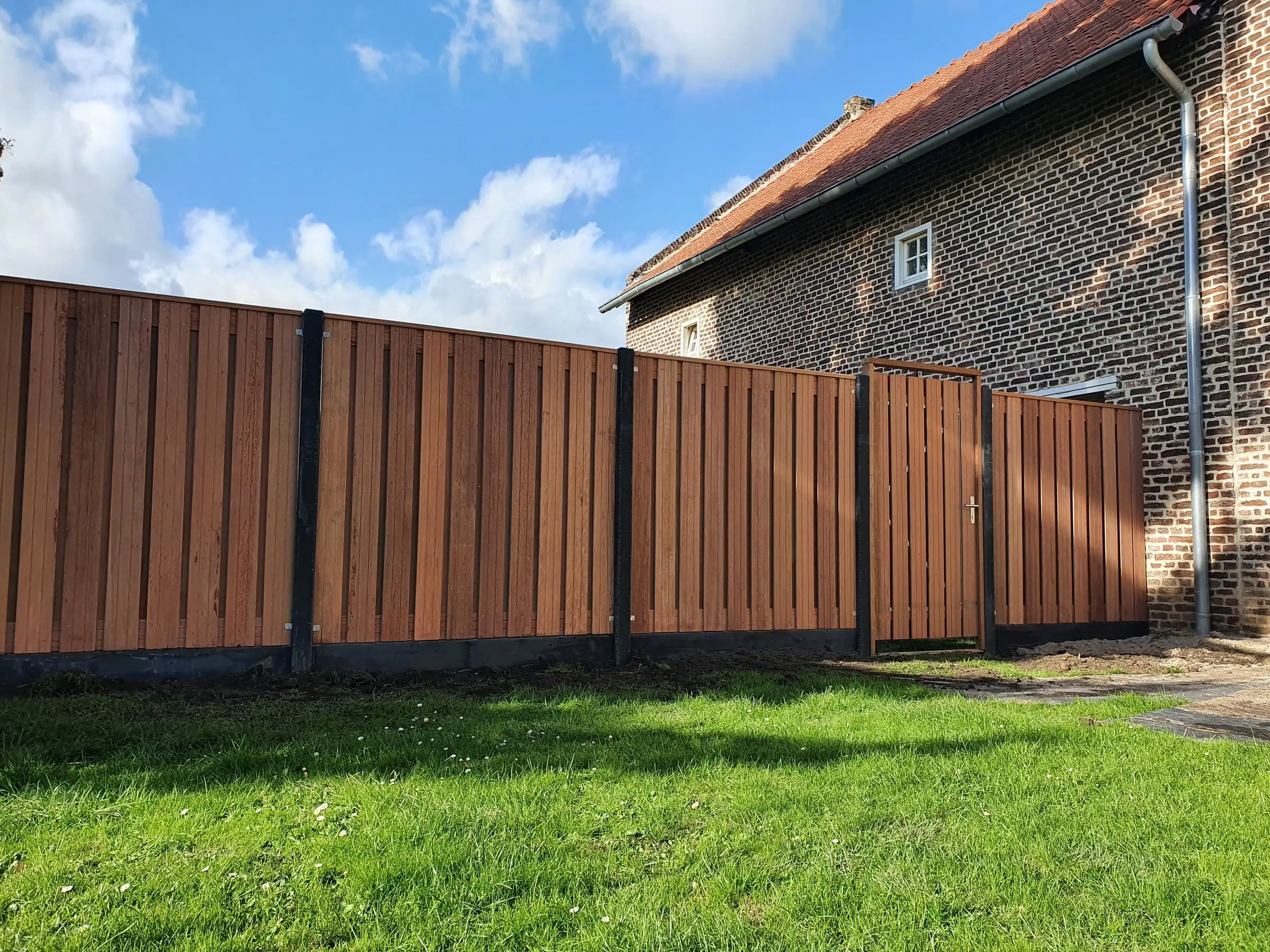 Schutting Kampioen - Projecten - Hout beton schutting montage hardhout 21 planks verticaal vlak met L beslag